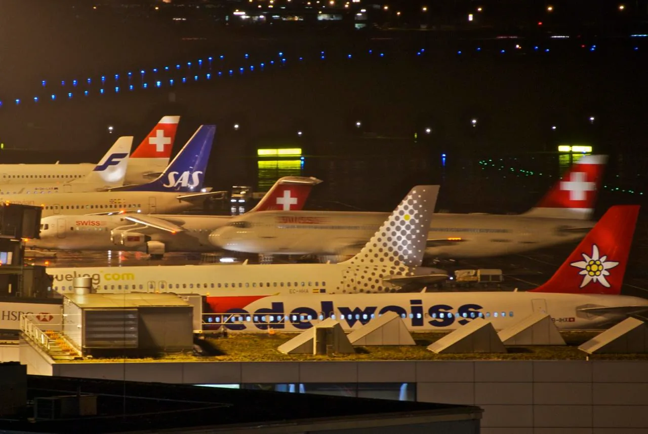 Vista al anochecer de aviones estacionados en el aeropuerto de Zúrich.