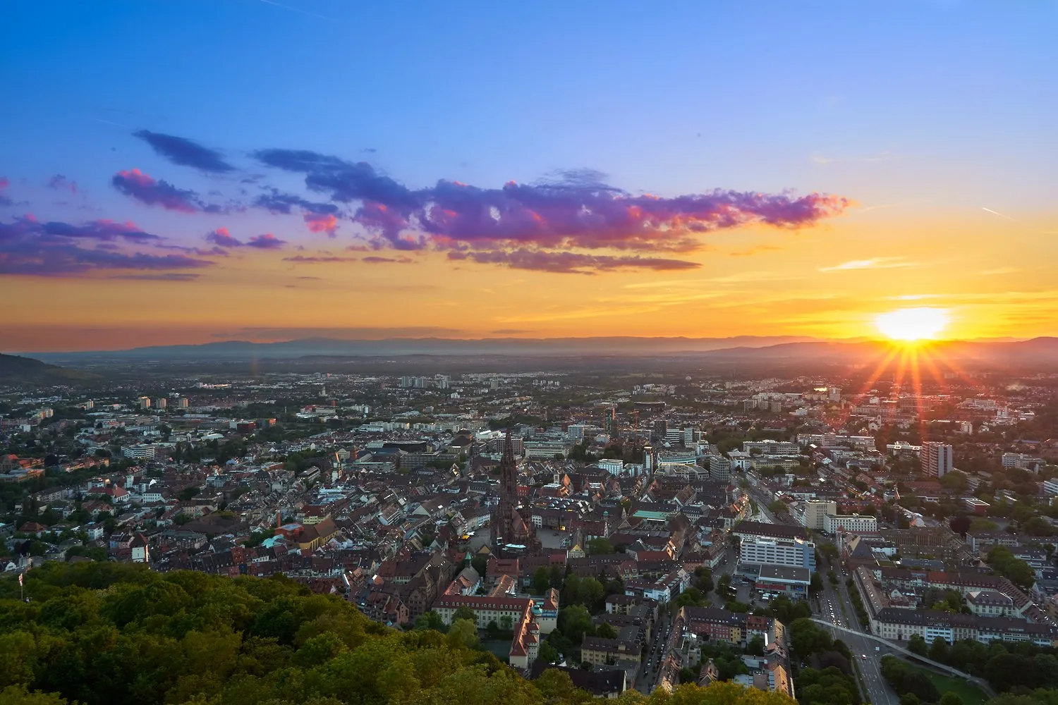Vue de Fribourg-en-Brisgau et de sa cathédrale sous un ciel de coucher de soleil.